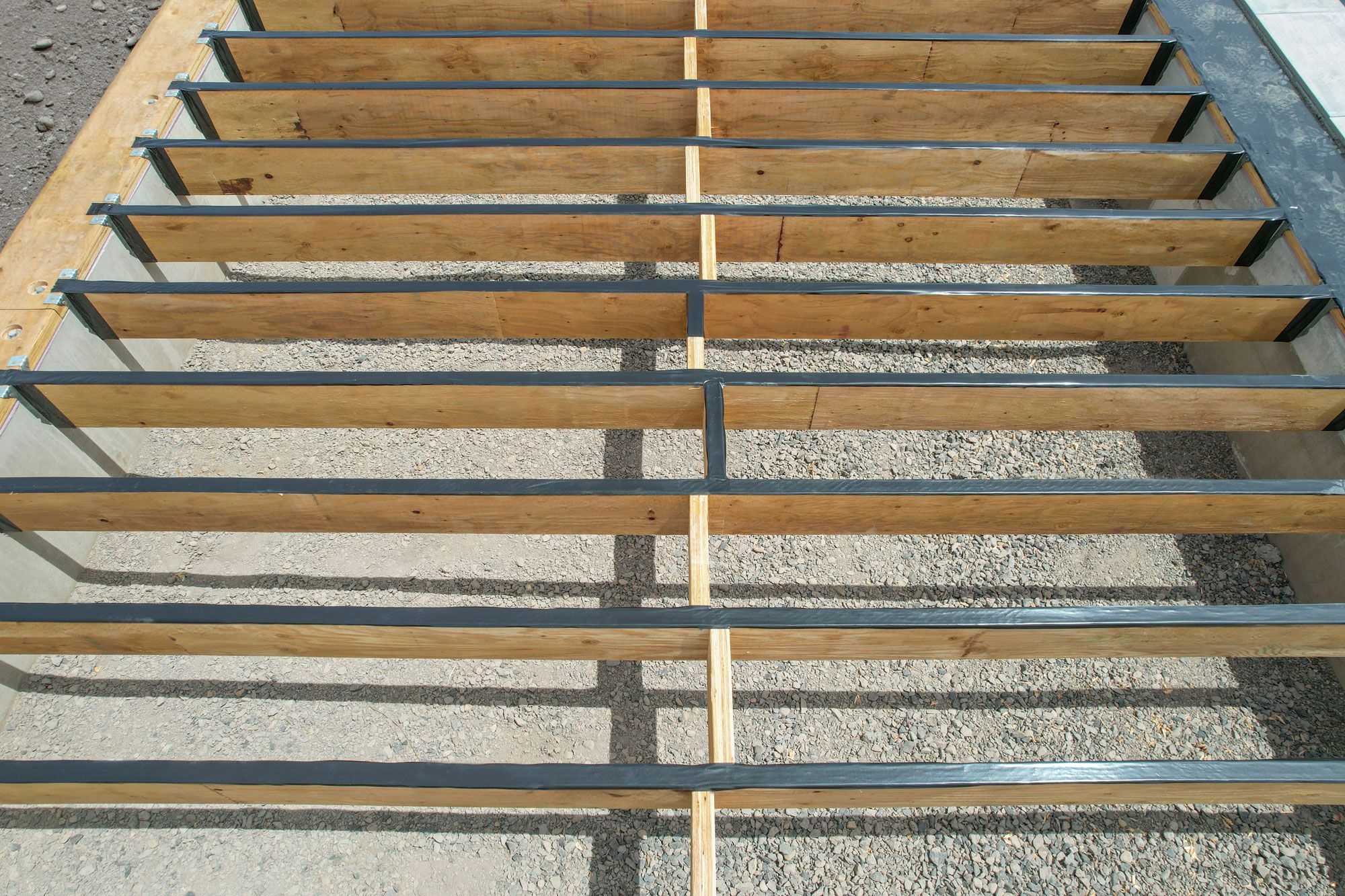 Person with hammer standing on a frame built with PWT Treated LVL