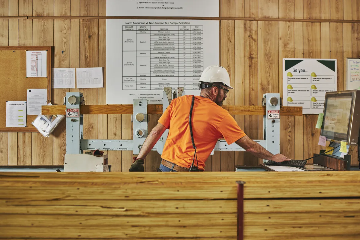 Man at desk in front of work posters typing on a keyboard
