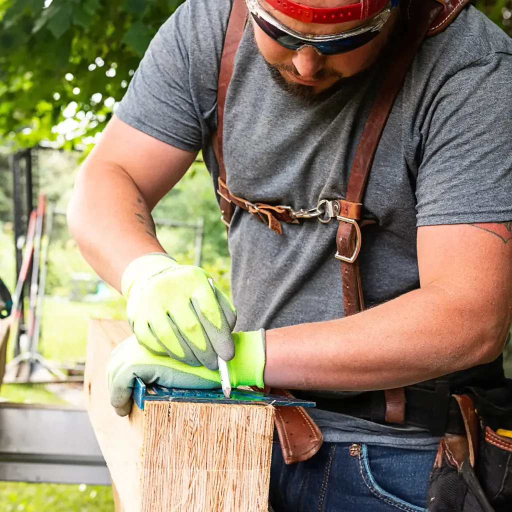 Man cutting billet beam with power tool