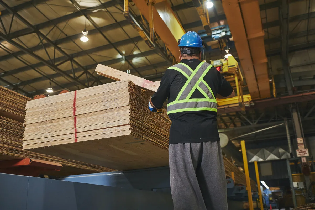 Man working in a PWT mill watching over stacked product