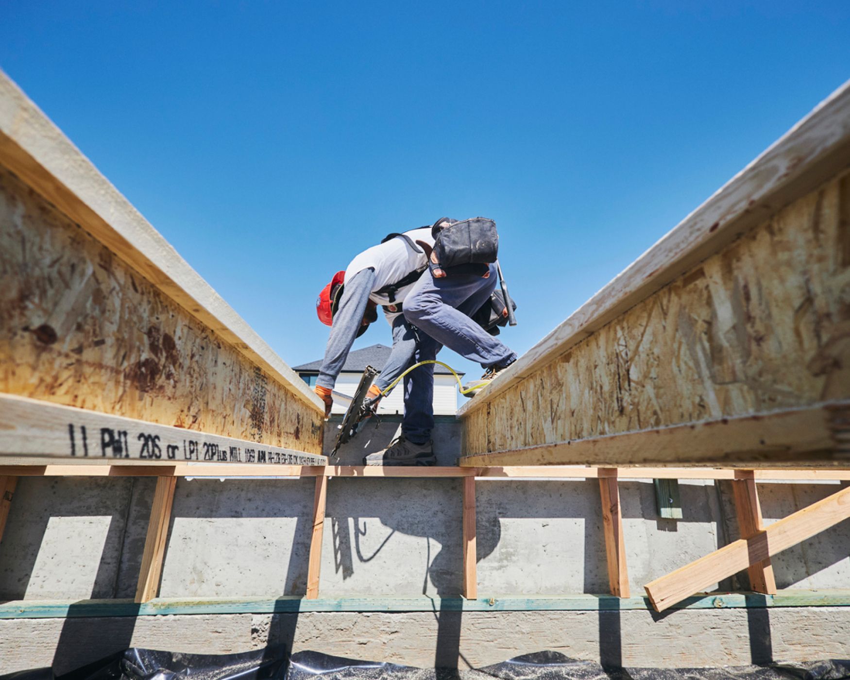 A worker nail-gunning some boards