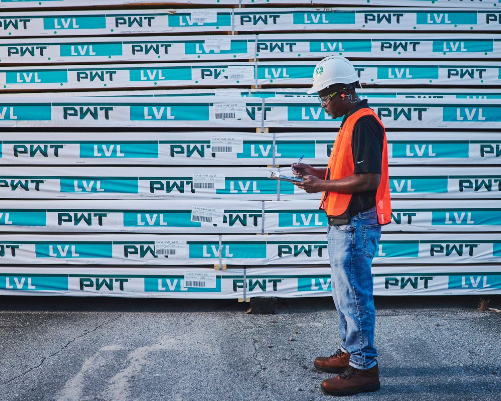 A worker in a hard hat checking LVL inventory