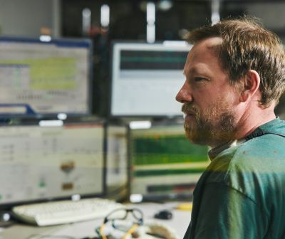 A worker at a bank of monitors