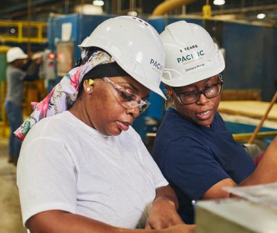 Two workers in hard hats in a warehouse